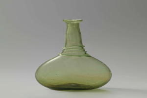 Ein grüner Glasweinkelch mit Verschluss, zylindrischer Form, breiter Basis, engem Hals und kunstvollen Verzierungen, mit glänzendem Finish.