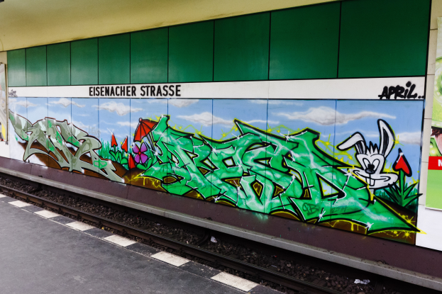 Ein Bahnsteig auf der linken Seite mit einer bunten, lebendigen Graffitiwand auf der rechten Seite.