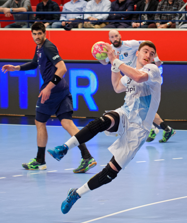 Eine Gruppe von Männern, die Handball auf einem Platz spielen, mit einem Ball in der Mitte, Zuschauern im Hintergrund und einer Tafel mit "Futsal-Weltmeisterschaft 2019" und den Tagen des Ereignisses.