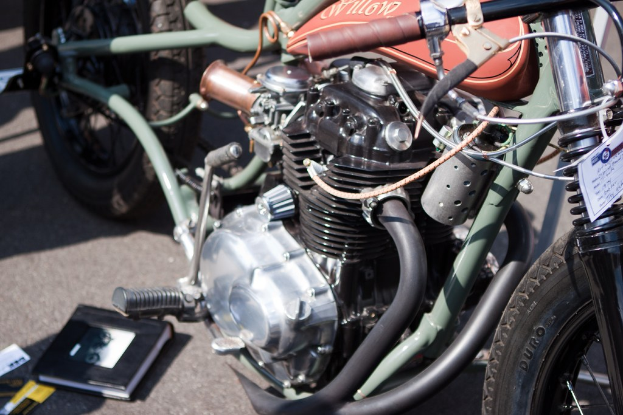 Mehrere Motorräder auf einer Straße geparkt mit einem Buch auf dem Sitz eines davon.