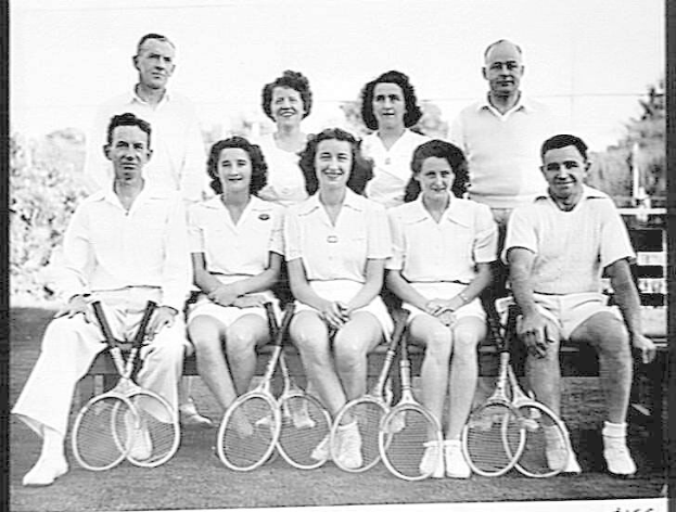 Ein Schwarz-Weiß-Foto von Menschen auf einer Bank sitzend, die lächeln und Tennisrackets halten, mit Bäumen und einem klaren Himmel im Hintergrund und dem Text "Tennis Hall of Fame" unten.