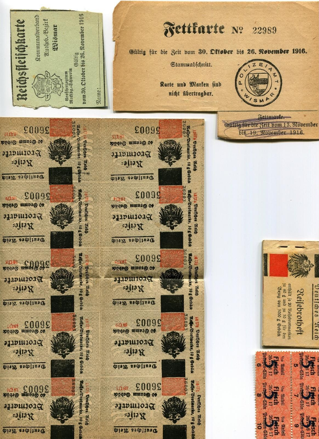 Sammlung alter deutscher Tickets und Marken auf einem weißen Hintergrund, einige mit gedrucktem Text und Zahlen.