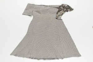 Schwarzes und weißes Seidenkleid mit engem Oberteil und vollem Rock bis zur Kniehöhe auf weißem Hintergrund.