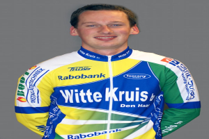 Ein männlicher Athlet posiert für ein Foto mit sichtbaren Sponsor-Logos auf seinem Hemd.