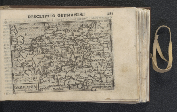 Offenes Buch auf einer schwarzen Oberfläche mit einer historischen Deutschlandkarte.