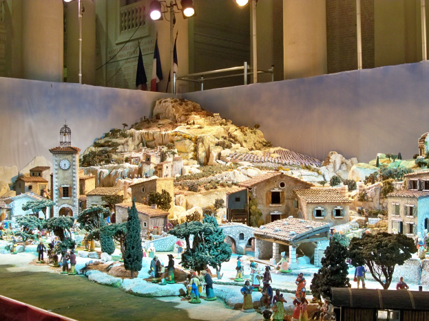Ein detailliertes Modell einer Krippe in einem Museum ausgestellt, mit Figuren, Strukturen und Beleuchtung.