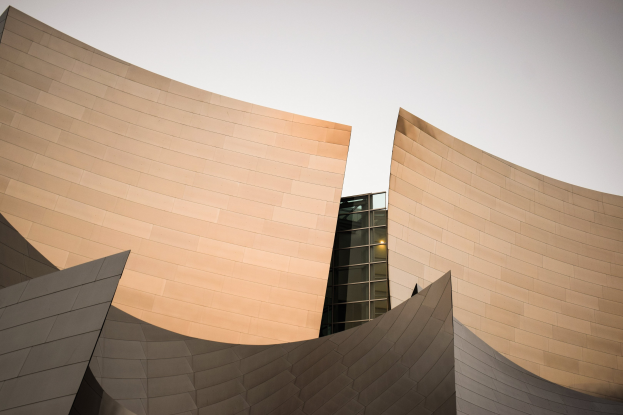 Moderner Konzertsaal mit Glasfenstern unter einem klaren blauen Himmel.