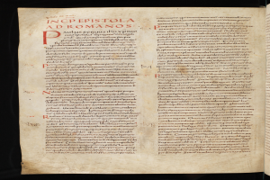 Ein offenes Buch mit roter Schrift in fetter Schriftart gegen einen schwarzen Hintergrund, das wie ein Brevier aussieht.